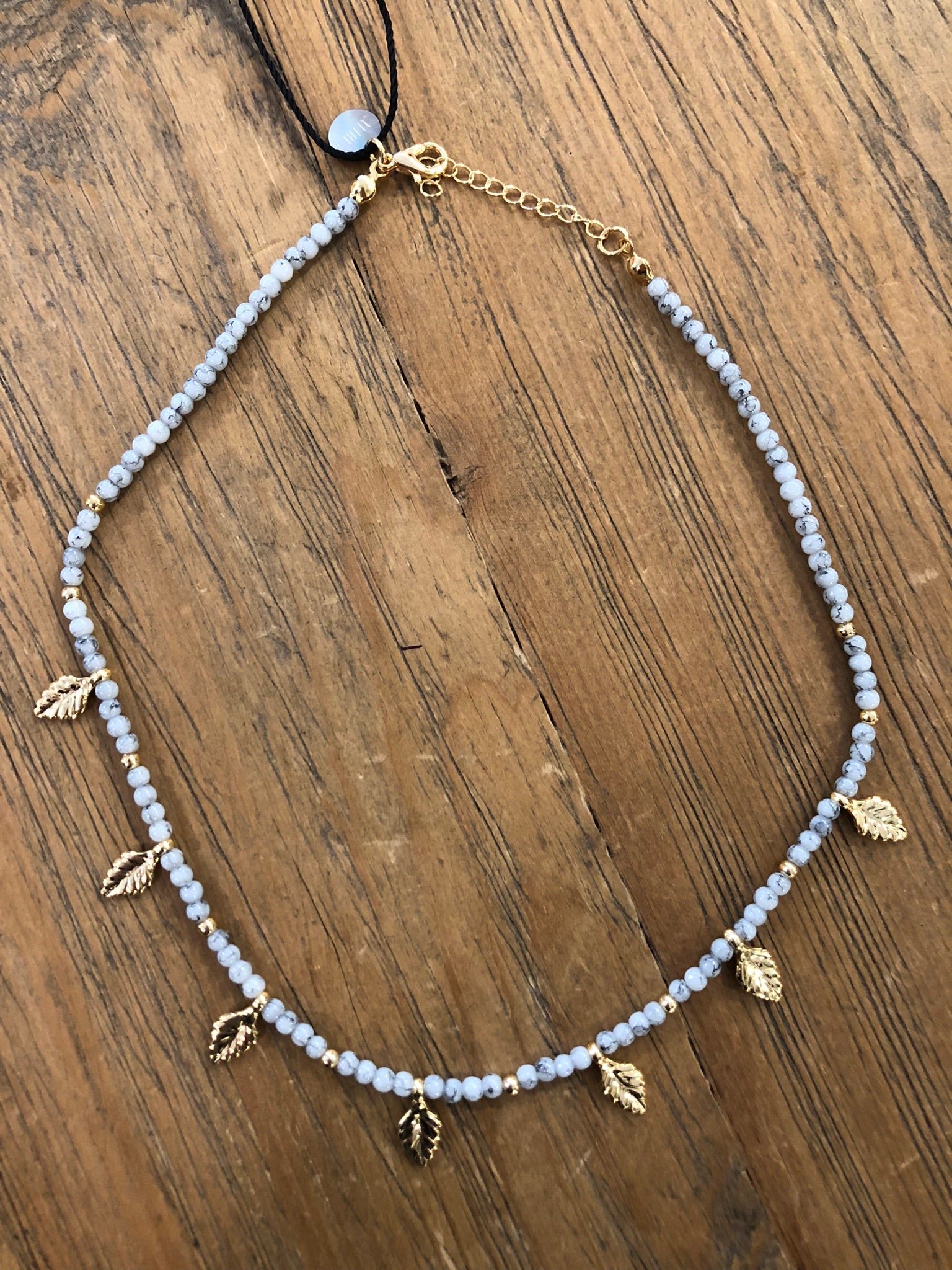 Collar corto tonos grises hojitas doradas “Alibey”